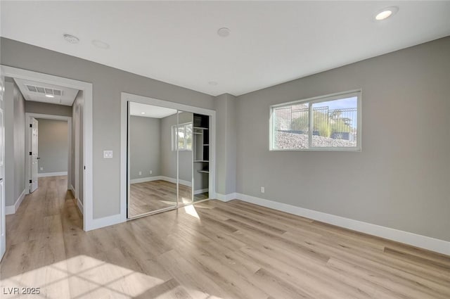 unfurnished bedroom with a closet and light hardwood / wood-style floors