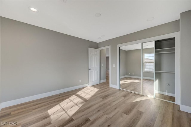 unfurnished bedroom featuring a closet and light hardwood / wood-style flooring