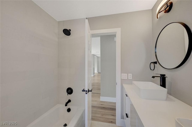 bathroom featuring tiled shower / bath combo and vanity