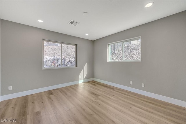 unfurnished room featuring light hardwood / wood-style floors and plenty of natural light