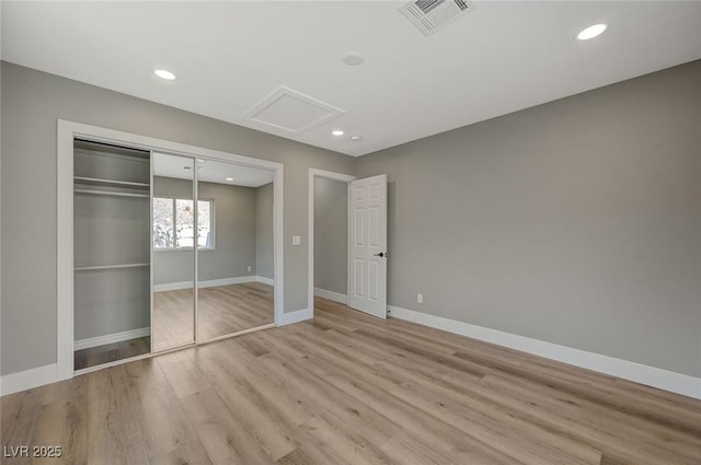 unfurnished bedroom with a closet and light wood-type flooring