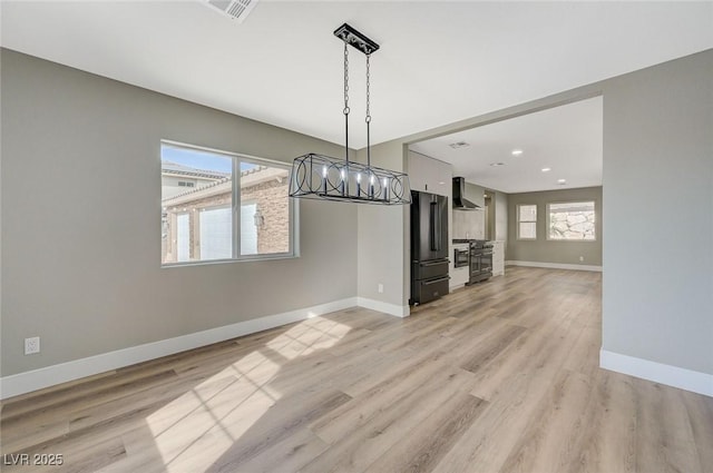 unfurnished dining area with a healthy amount of sunlight and light hardwood / wood-style flooring