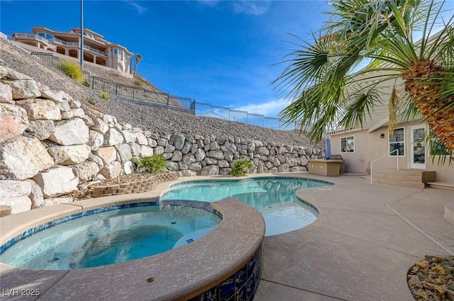 view of pool with an in ground hot tub