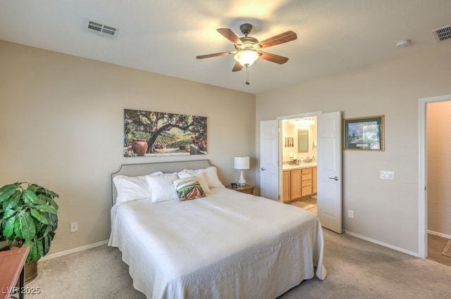 bedroom with ceiling fan, connected bathroom, and light carpet