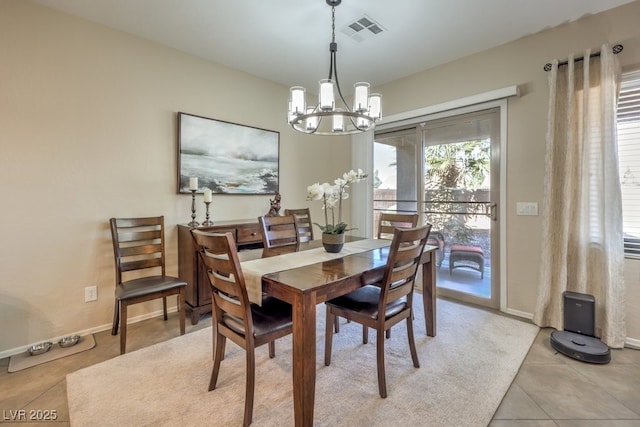 tiled dining room with an inviting chandelier