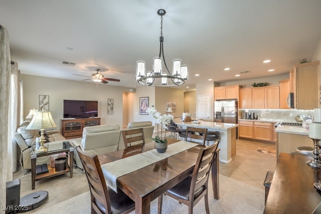 dining area featuring light tile patterned flooring and ceiling fan with notable chandelier