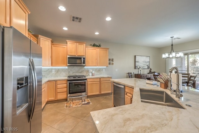 kitchen featuring backsplash, a notable chandelier, sink, appliances with stainless steel finishes, and light brown cabinets