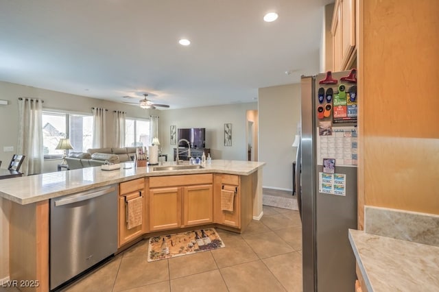 kitchen with ceiling fan, kitchen peninsula, sink, and stainless steel appliances