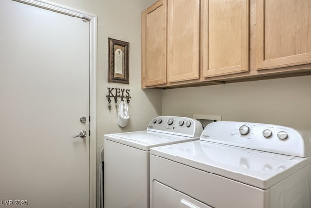 clothes washing area with cabinets and independent washer and dryer