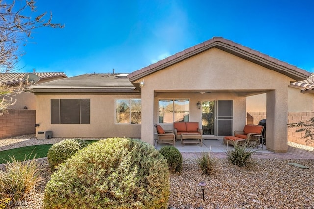 back of house with an outdoor living space and a patio area