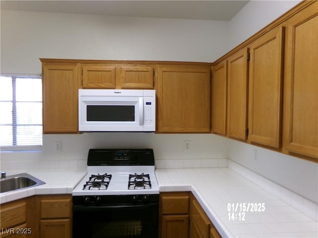 kitchen featuring sink, tile counters, and gas stove