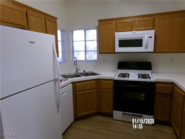 kitchen featuring tile countertops, dark hardwood / wood-style floors, sink, and white appliances