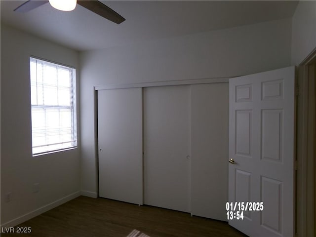 unfurnished bedroom with ceiling fan, dark hardwood / wood-style floors, and a closet