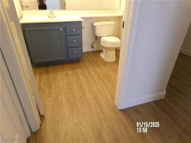 bathroom featuring toilet, wood-type flooring, and vanity