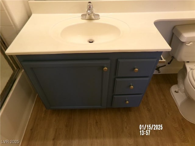 bathroom with toilet, vanity, and hardwood / wood-style floors