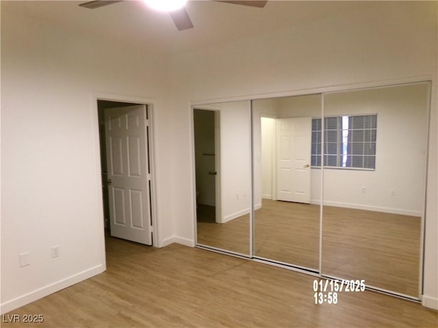 unfurnished bedroom featuring ceiling fan, hardwood / wood-style flooring, and a closet