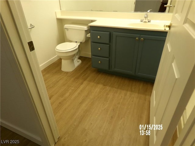 bathroom featuring toilet, hardwood / wood-style floors, and vanity