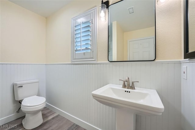 bathroom featuring toilet, wood-type flooring, and sink