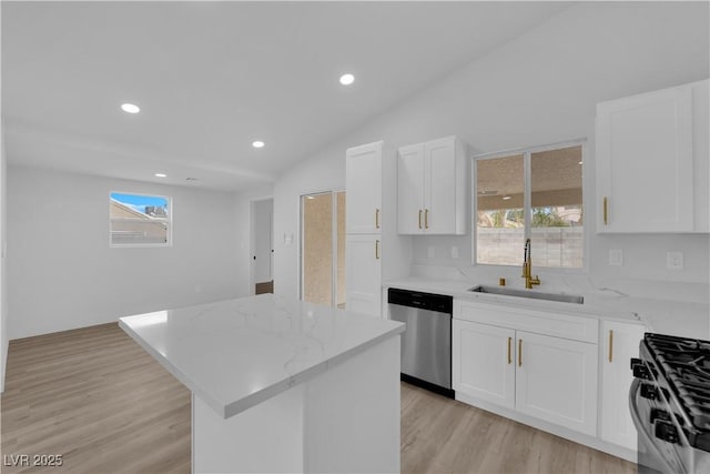 kitchen featuring a kitchen island, stainless steel dishwasher, sink, white cabinets, and gas range