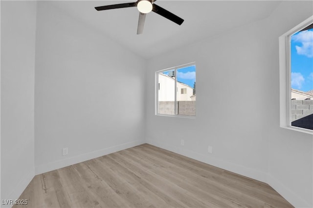 spare room with ceiling fan, lofted ceiling, a wealth of natural light, and light hardwood / wood-style flooring