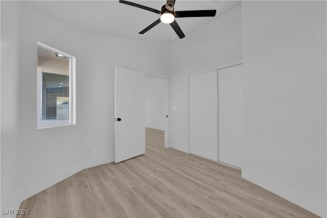 unfurnished bedroom with ceiling fan, light wood-type flooring, and a closet