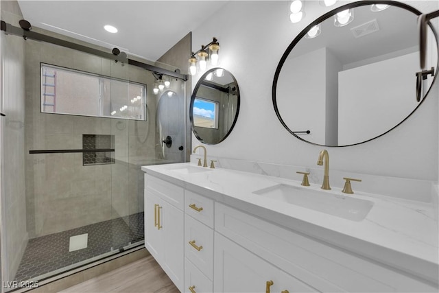 bathroom with hardwood / wood-style flooring, an enclosed shower, and vanity