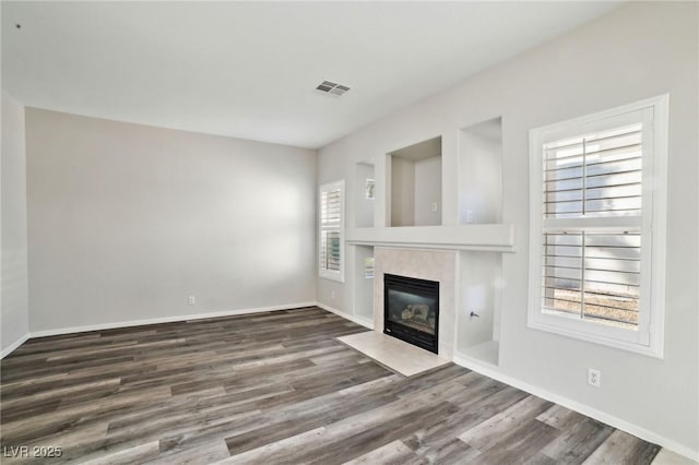 unfurnished living room featuring dark hardwood / wood-style flooring and a healthy amount of sunlight