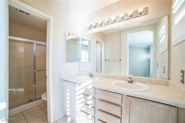 bathroom with an enclosed shower, vanity, tile patterned floors, and toilet