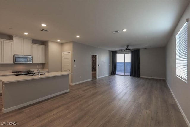 kitchen with white cabinetry, ceiling fan, dark hardwood / wood-style floors, range, and sink