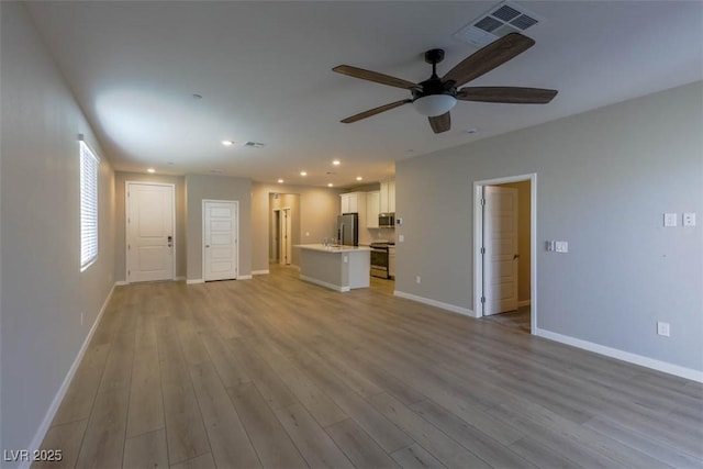 unfurnished living room featuring ceiling fan and light hardwood / wood-style flooring