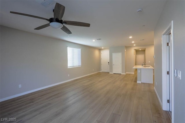 unfurnished living room featuring light hardwood / wood-style floors and ceiling fan