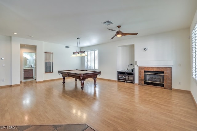 game room featuring ceiling fan, pool table, a fireplace, and light hardwood / wood-style flooring