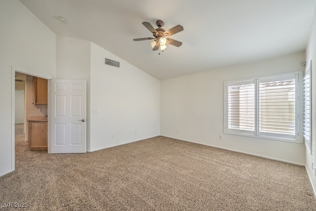 carpeted empty room with high vaulted ceiling and ceiling fan