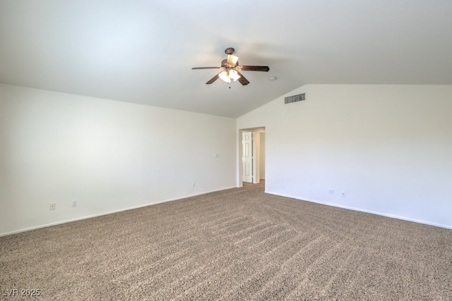 empty room featuring lofted ceiling, carpet flooring, visible vents, and a ceiling fan