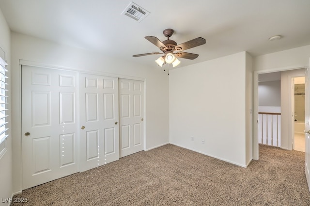 unfurnished bedroom with light colored carpet, a ceiling fan, baseboards, visible vents, and a closet