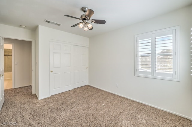 unfurnished bedroom with carpet, a closet, visible vents, ceiling fan, and baseboards