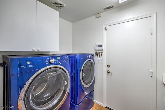 laundry area with cabinets and washing machine and clothes dryer