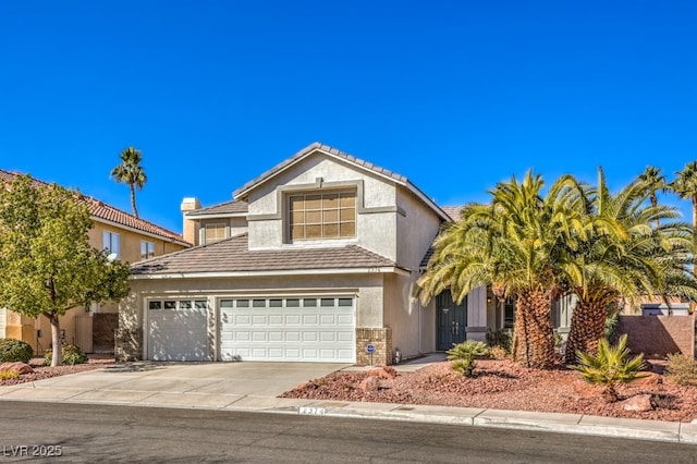 view of front of property featuring driveway, a tile roof, a garage, and stucco siding