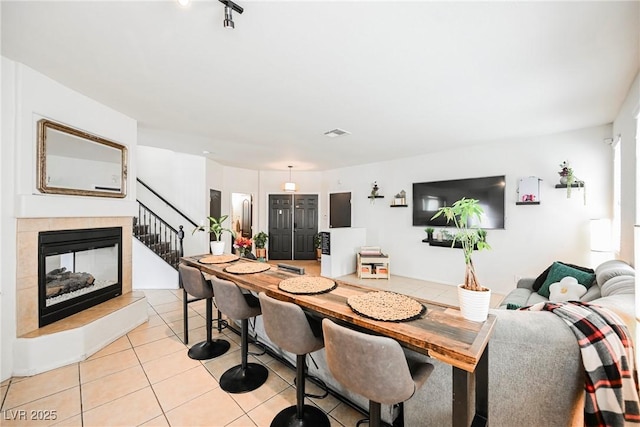 dining area with a fireplace and light tile patterned flooring