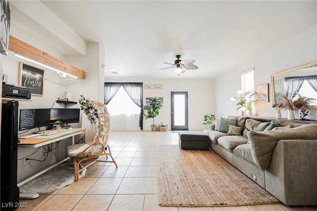 tiled living room with ceiling fan and built in desk