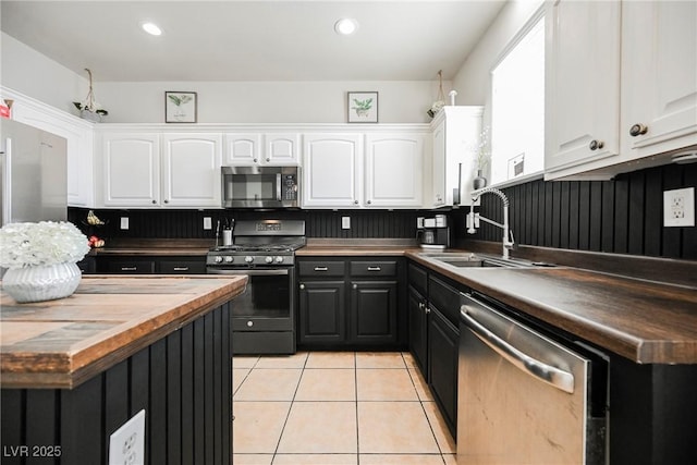 kitchen featuring light tile patterned floors, sink, white cabinetry, and appliances with stainless steel finishes