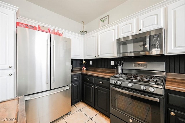 kitchen with light tile patterned floors, appliances with stainless steel finishes, and white cabinets