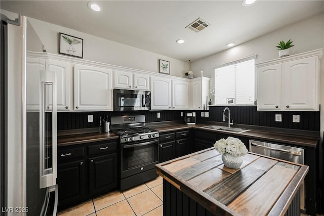 kitchen featuring light tile patterned floors, sink, white cabinets, and appliances with stainless steel finishes