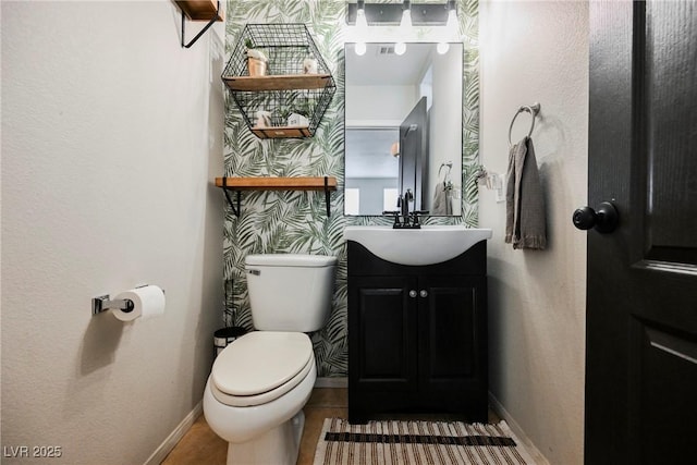 bathroom featuring toilet, vanity, and tile patterned flooring