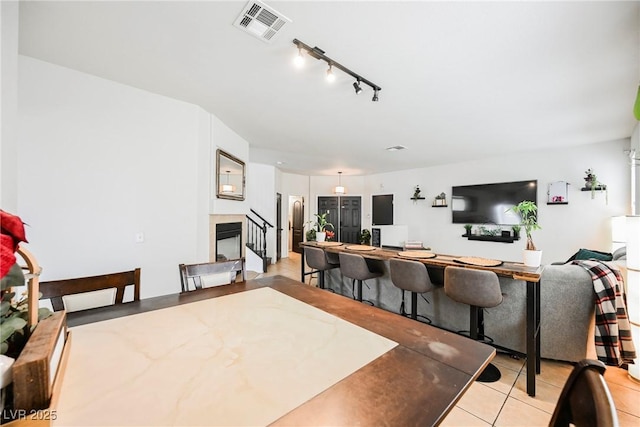 dining area with light tile patterned flooring and rail lighting