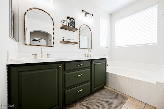 bathroom with tiled bath, tile patterned floors, and vanity