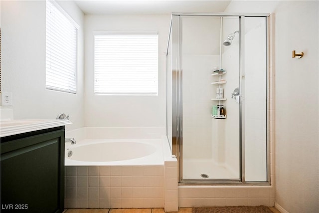 bathroom with independent shower and bath, a wealth of natural light, tile patterned flooring, and vanity