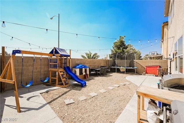 view of play area featuring a trampoline and a patio