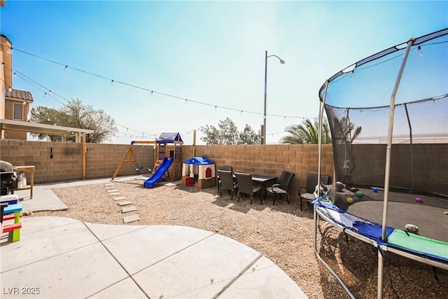 view of playground featuring a trampoline and a patio