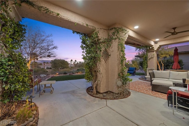 patio terrace at dusk with an outdoor living space and ceiling fan